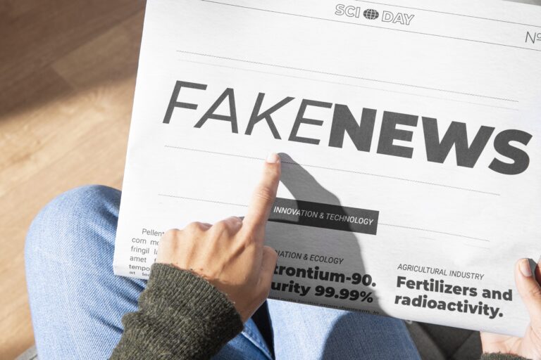 Pessoa com jornal na mão com o título Fake News
